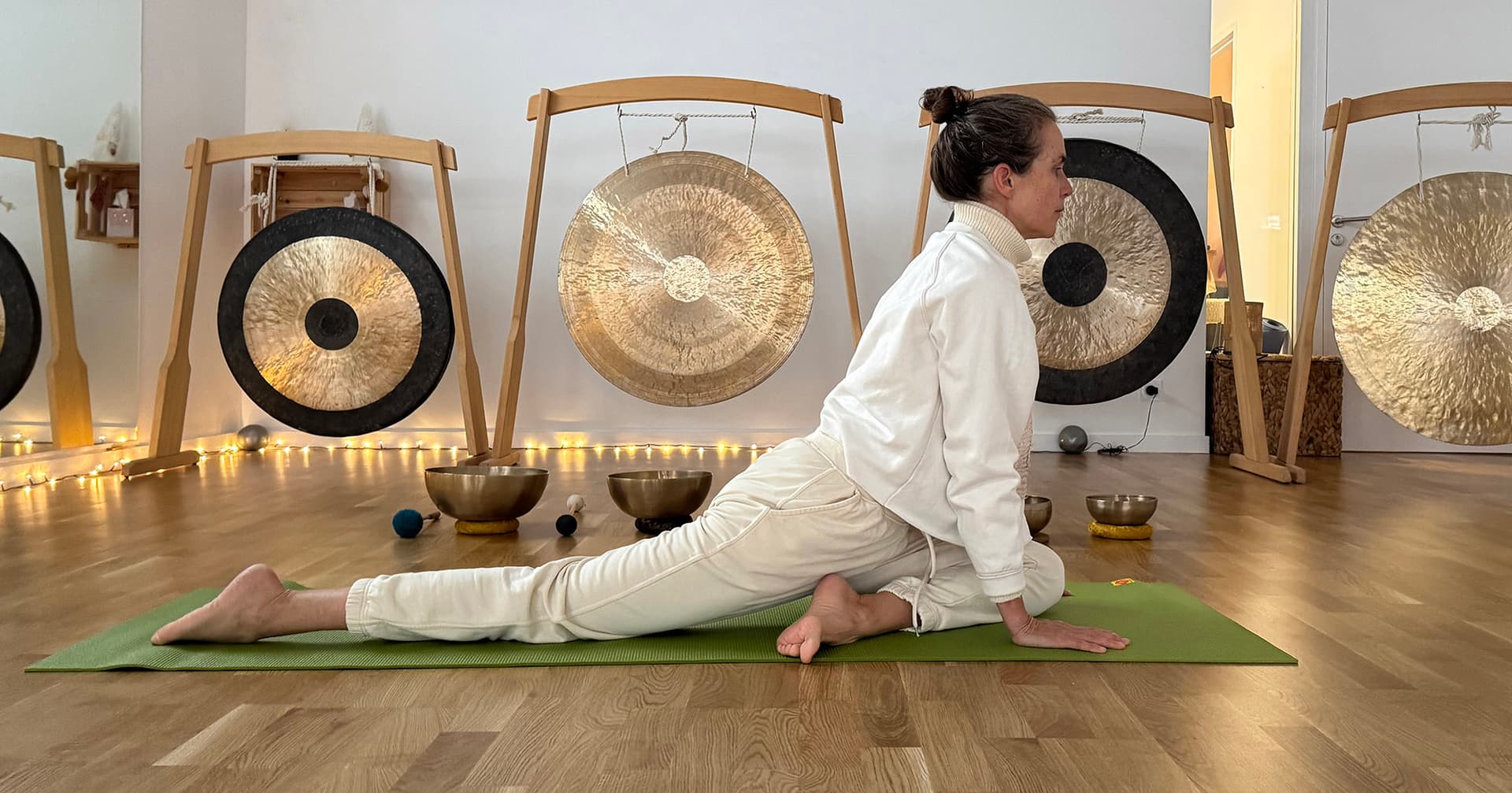 Posture de yoga devant les gongs et les bols chantants